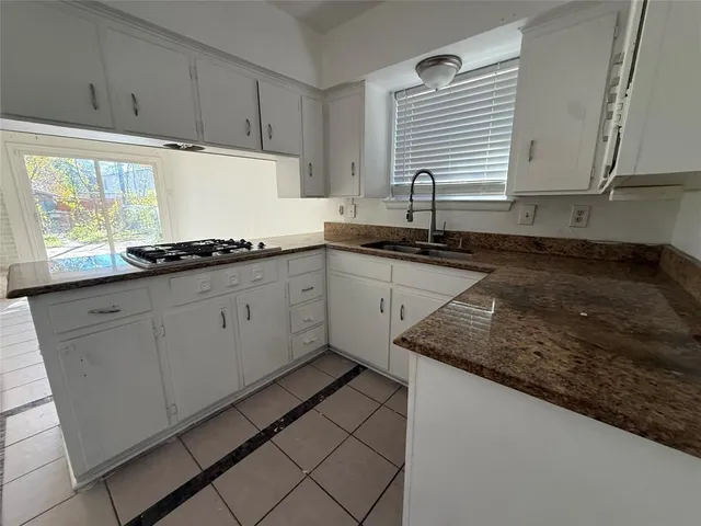 a kitchen with granite countertop white cabinets and white appliances