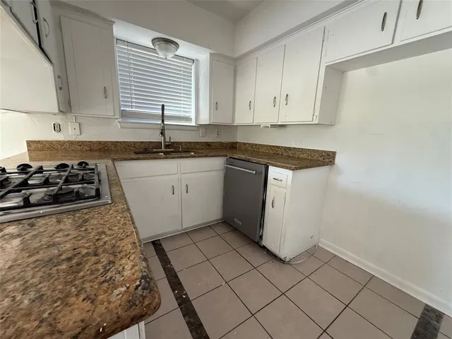 a kitchen with granite countertop white cabinets and white appliances