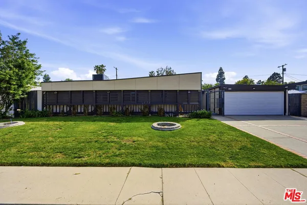 a view of a house with a backyard and a garden