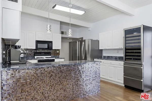 a kitchen with granite countertop white cabinets and white appliances