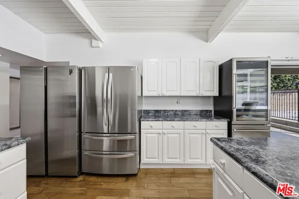 a kitchen with granite countertop a sink and white cabinets