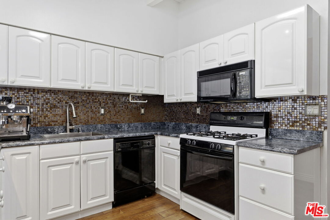 18342 Blackhawk Street Porter Ranch, CA 91326 - Photo 14 of 56 a kitchen with granite countertop white cabinets and white appliances