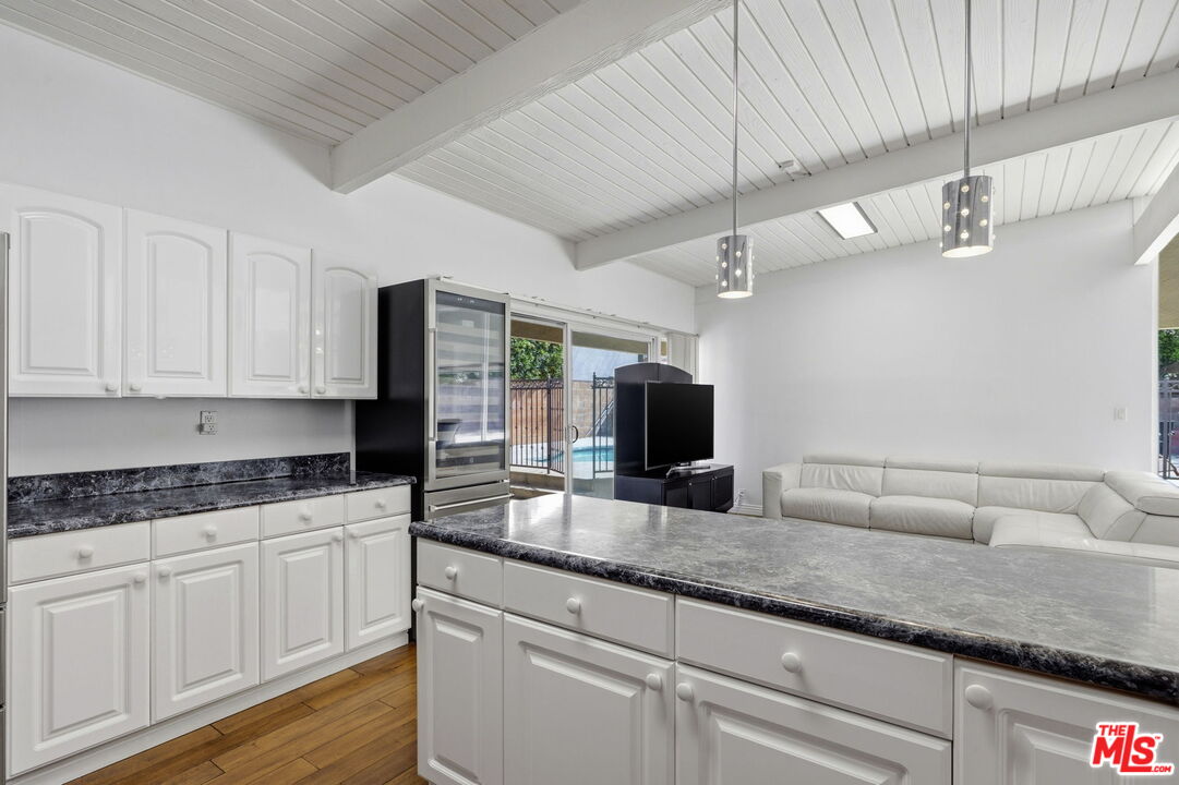 18342 Blackhawk Street Porter Ranch, CA 91326 - Photo 15 of 56 a kitchen with granite countertop a sink and white cabinets