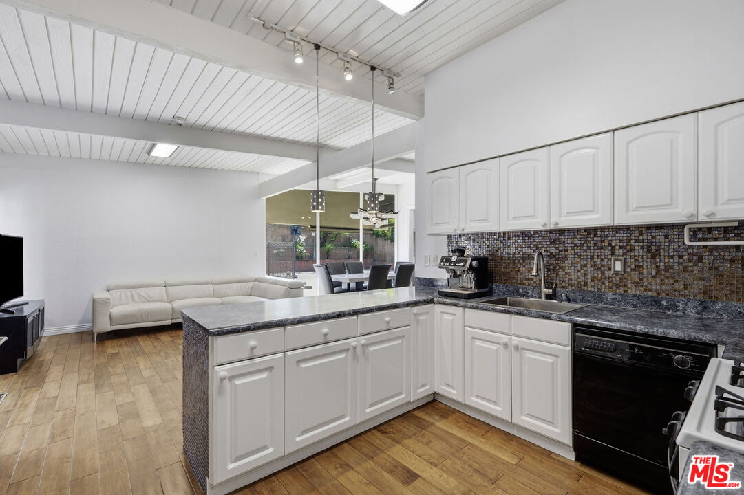 18342 Blackhawk Street Porter Ranch, CA 91326 - Photo 16 of 56 a kitchen with a sink dishwasher and white cabinets with wooden floor