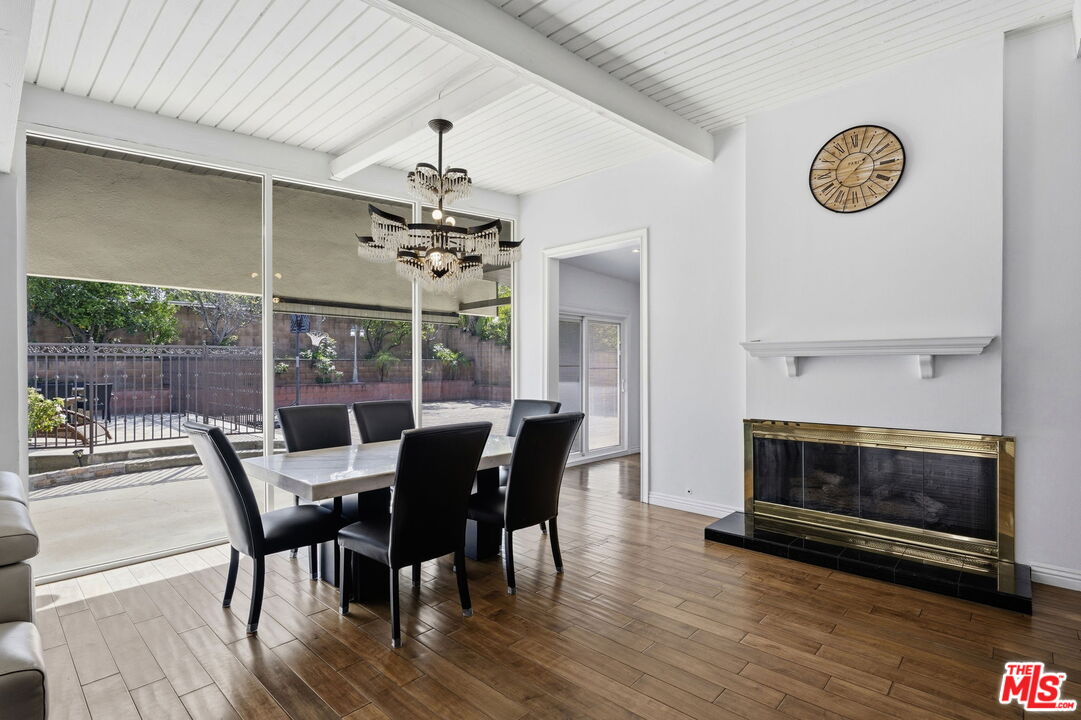 18342 Blackhawk Street Porter Ranch, CA 91326 - Photo 20 of 56 a view of a dining room with furniture wooden floor and a fireplace