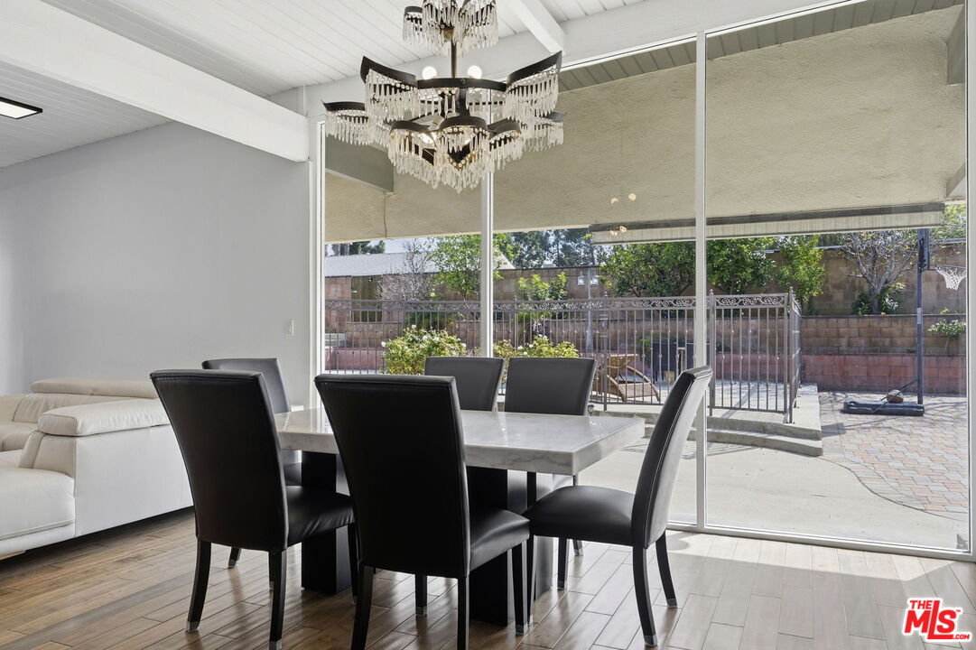 18342 Blackhawk Street Porter Ranch, CA 91326 - Photo 21 of 56 a view of a dining room with furniture wooden floor and chandelier