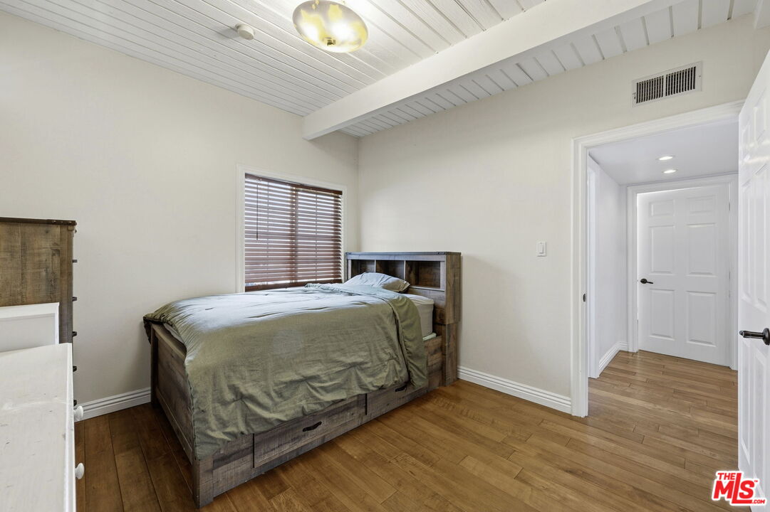 18342 Blackhawk Street Porter Ranch, CA 91326 - Photo 28 of 56 a bedroom with a bed and wooden floor