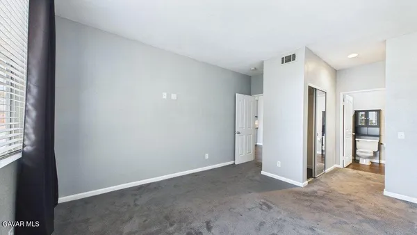 an empty room with closet and windows