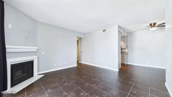 an empty room with a fireplace and wooden floor
