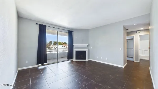 an empty room with windows and fireplace