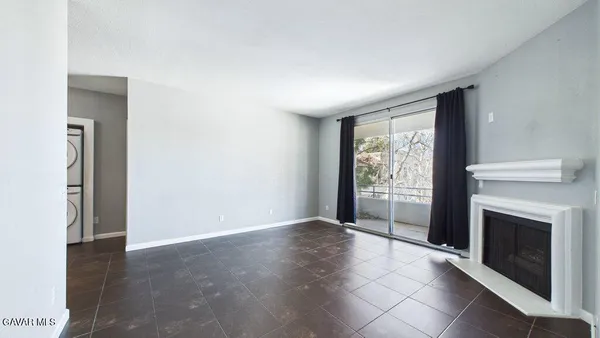 a view of an empty room with a fireplace and a window