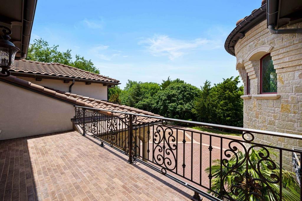 2115 Paradise Rnch Trail McKinney, TX 75071 - Photo 32 of 40 Exterior balcony featuring brick-patterned flooring, ornate wrought iron railing, and a stone facade
