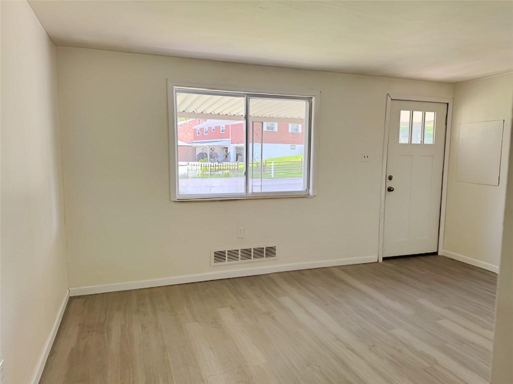 279 Olympic Road Pittsburgh, PA 15236 - Photo 6 of 25 an empty room with wooden floor and windows