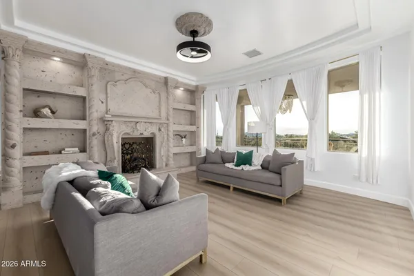 a living room with fireplace furniture and a large window
