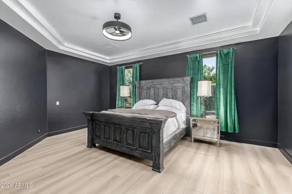 a bed sitting in a spacious bedroom next to a window