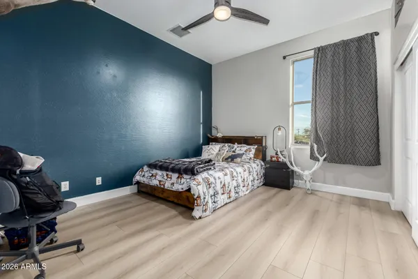 a bedroom with a large bed and wooden floor