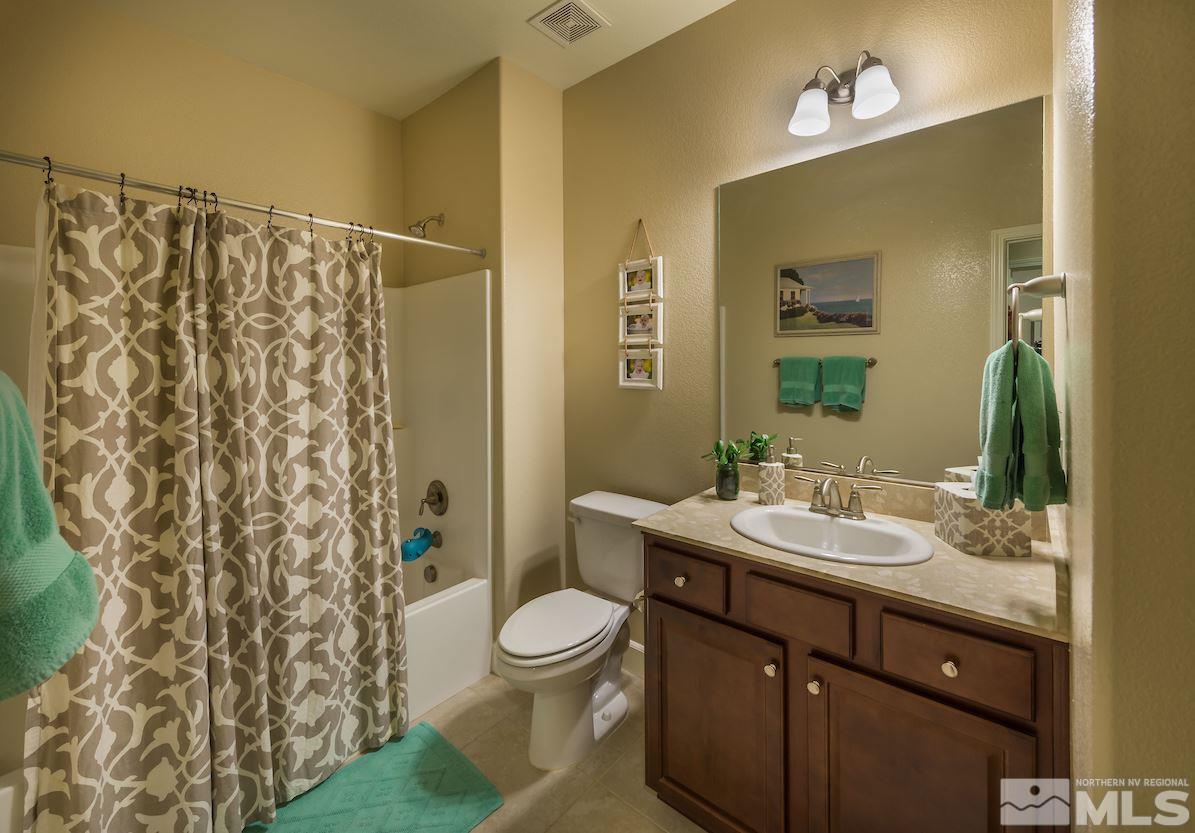 10045 Ignacio Circle Reno, NV 89521 - Photo 11 of 12 a bathroom with a granite countertop sink toilet and shower