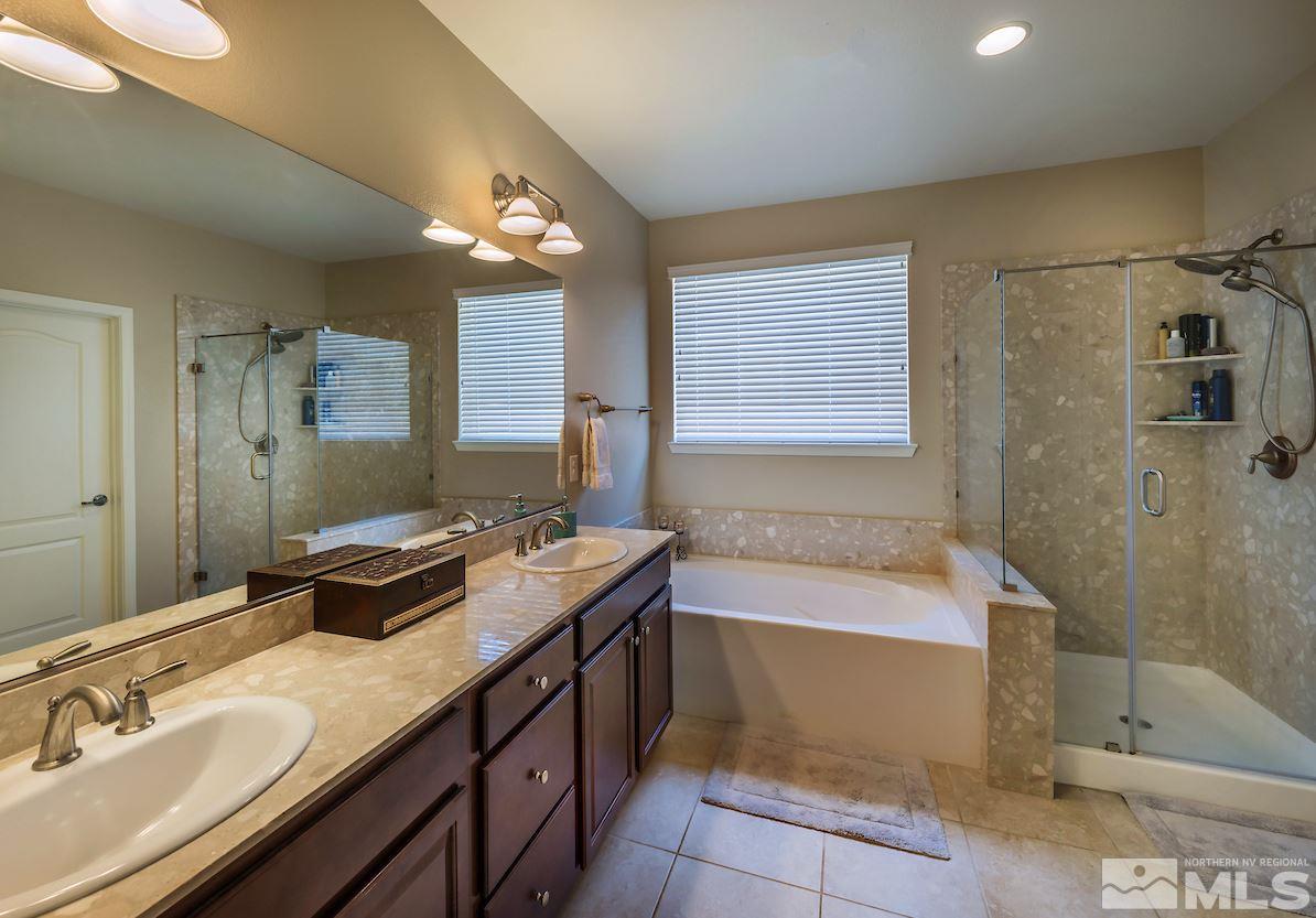 10045 Ignacio Circle Reno, NV 89521 - Photo 8 of 12 a bathroom with a tub sink and mirror