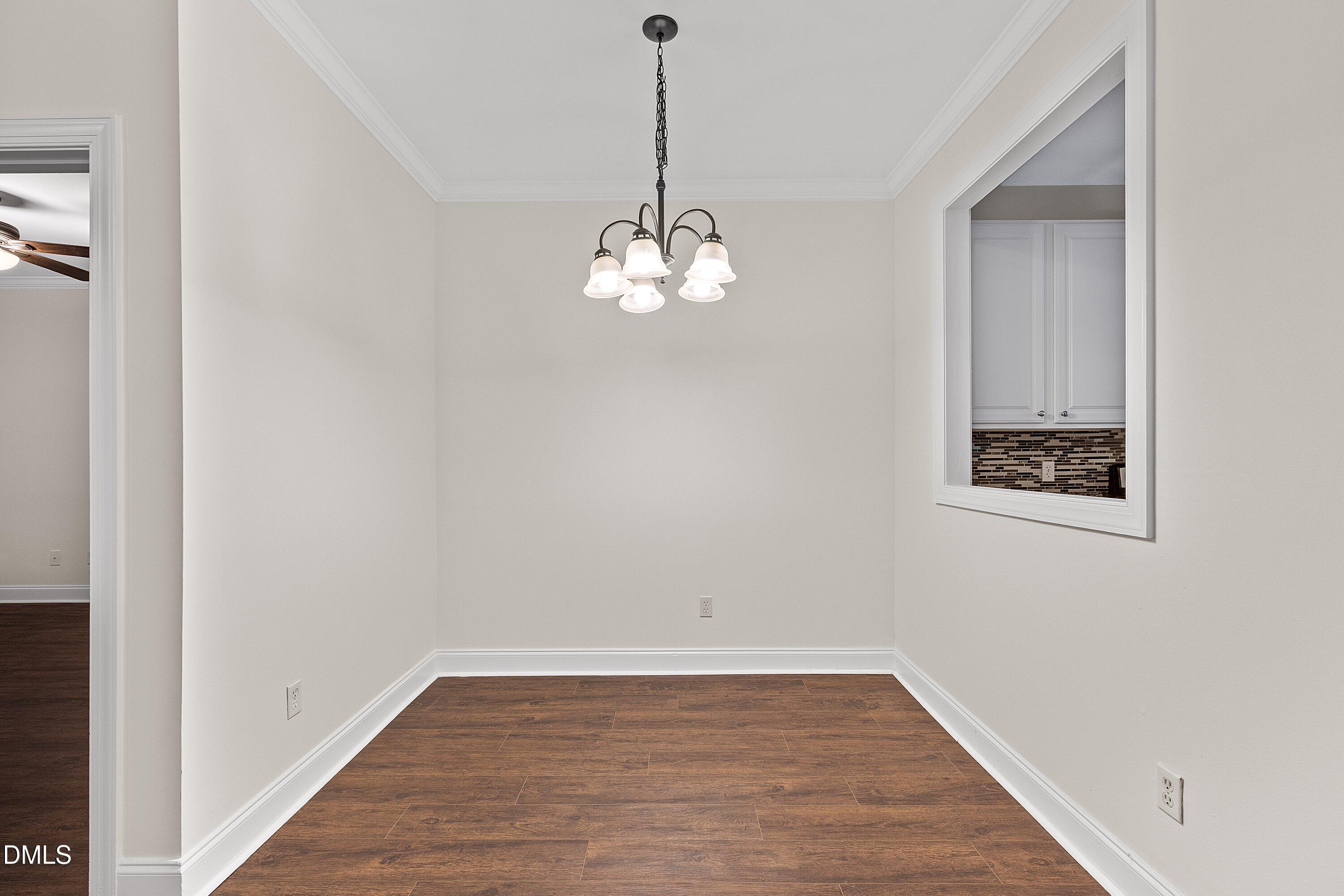 4120 Standing Rock Way Raleigh, NC 27604 - Photo 11 of 37 a view of a hallway with wooden floor and a chandelier