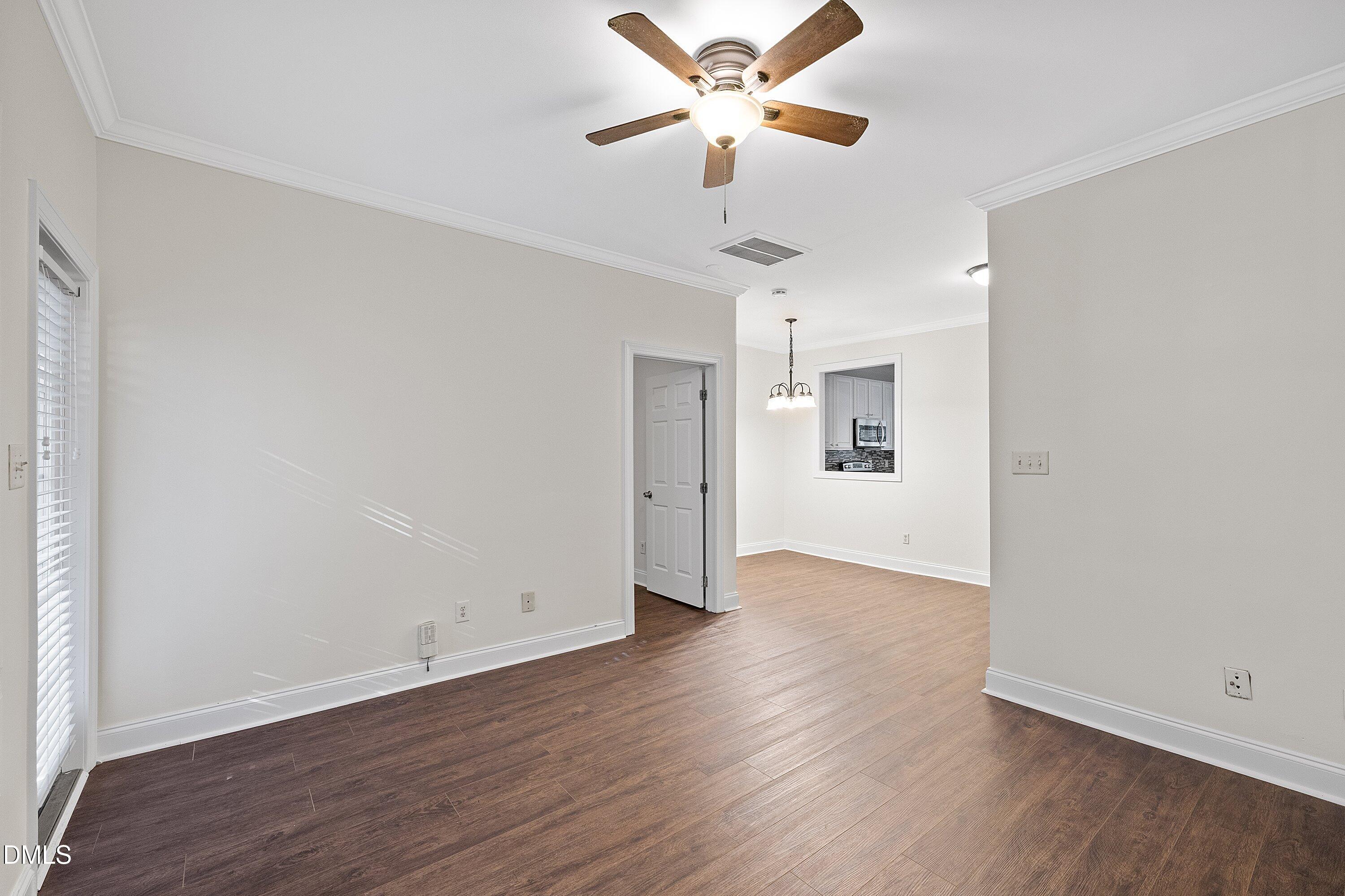 4120 Standing Rock Way Raleigh, NC 27604 - Photo 16 of 37 an empty room with wooden floor ceiling fan and windows