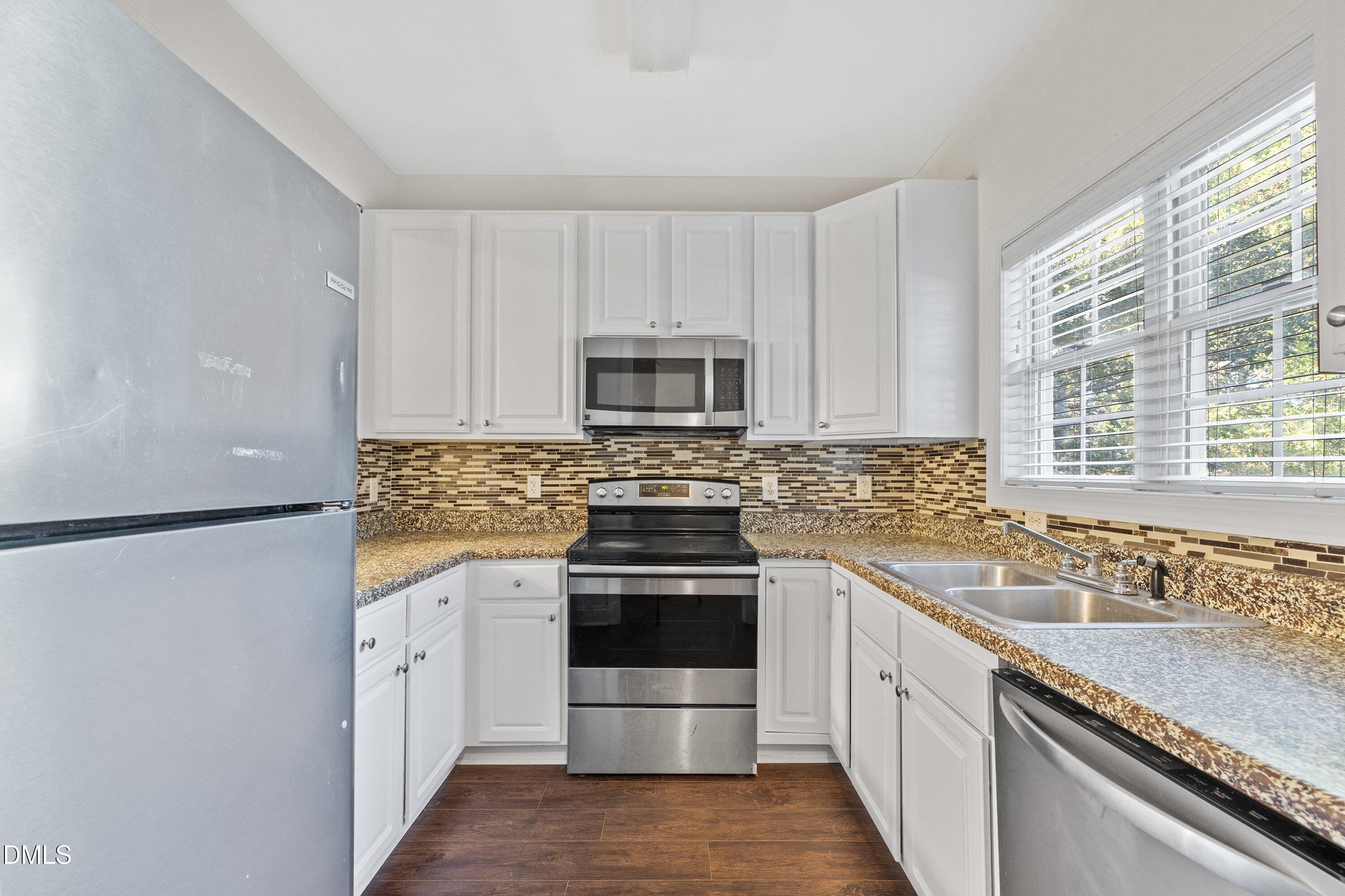 4120 Standing Rock Way Raleigh, NC 27604 - Photo 6 of 37 a kitchen with granite countertop a stove sink and refrigerator