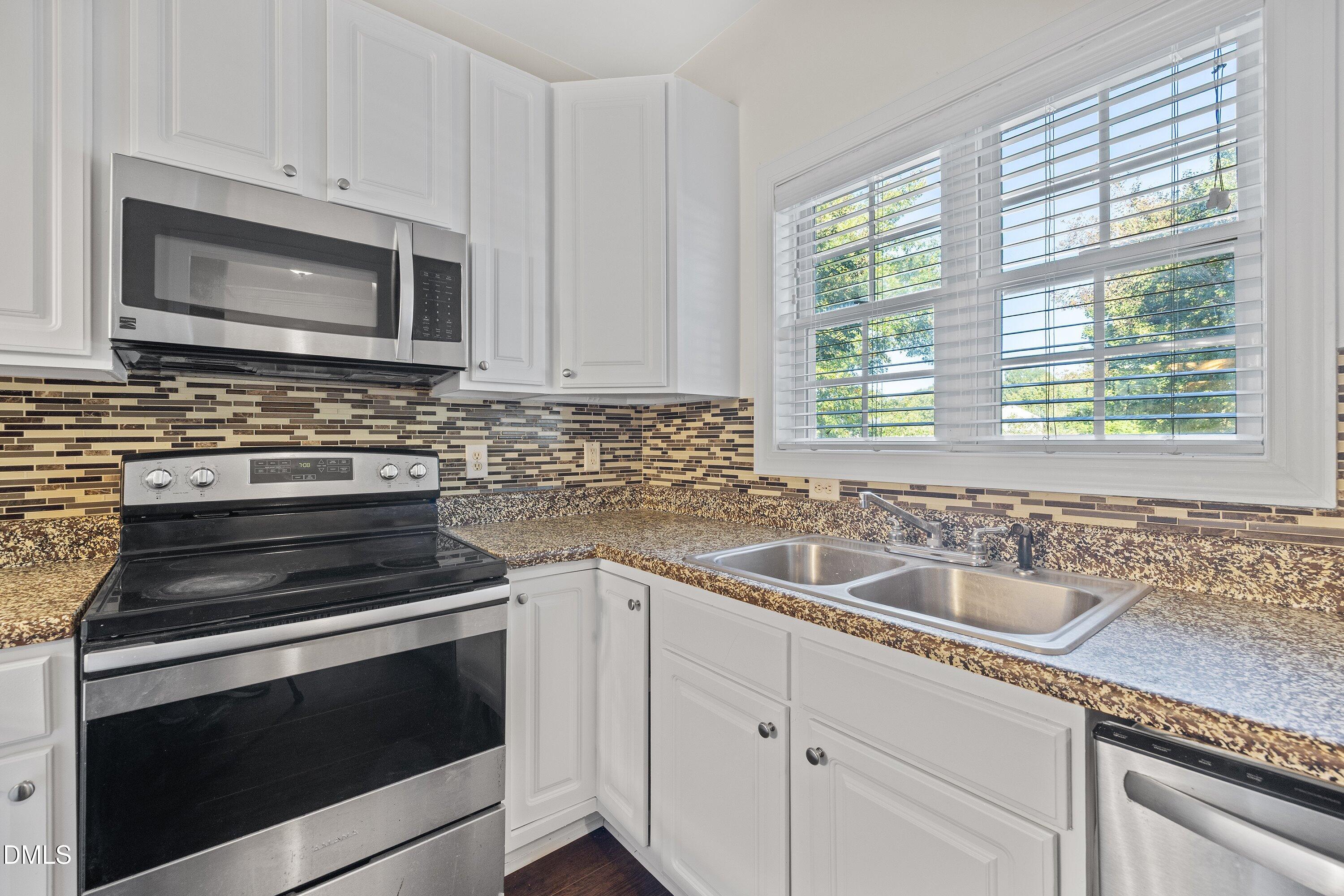 4120 Standing Rock Way Raleigh, NC 27604 - Photo 7 of 37 a kitchen with granite countertop a stove microwave and sink