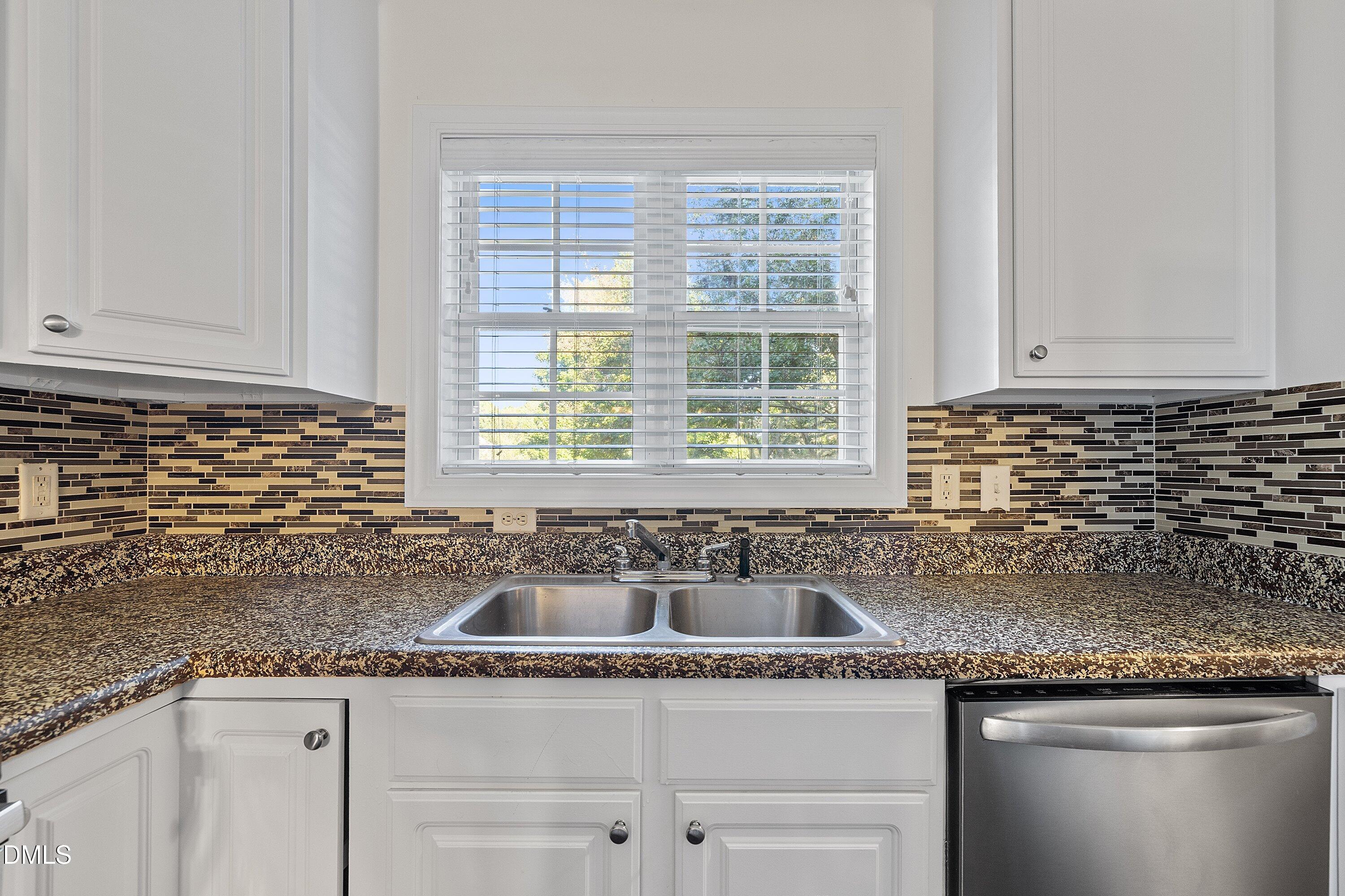 4120 Standing Rock Way Raleigh, NC 27604 - Photo 8 of 37 a kitchen with granite countertop a sink and a white wooden cabinets