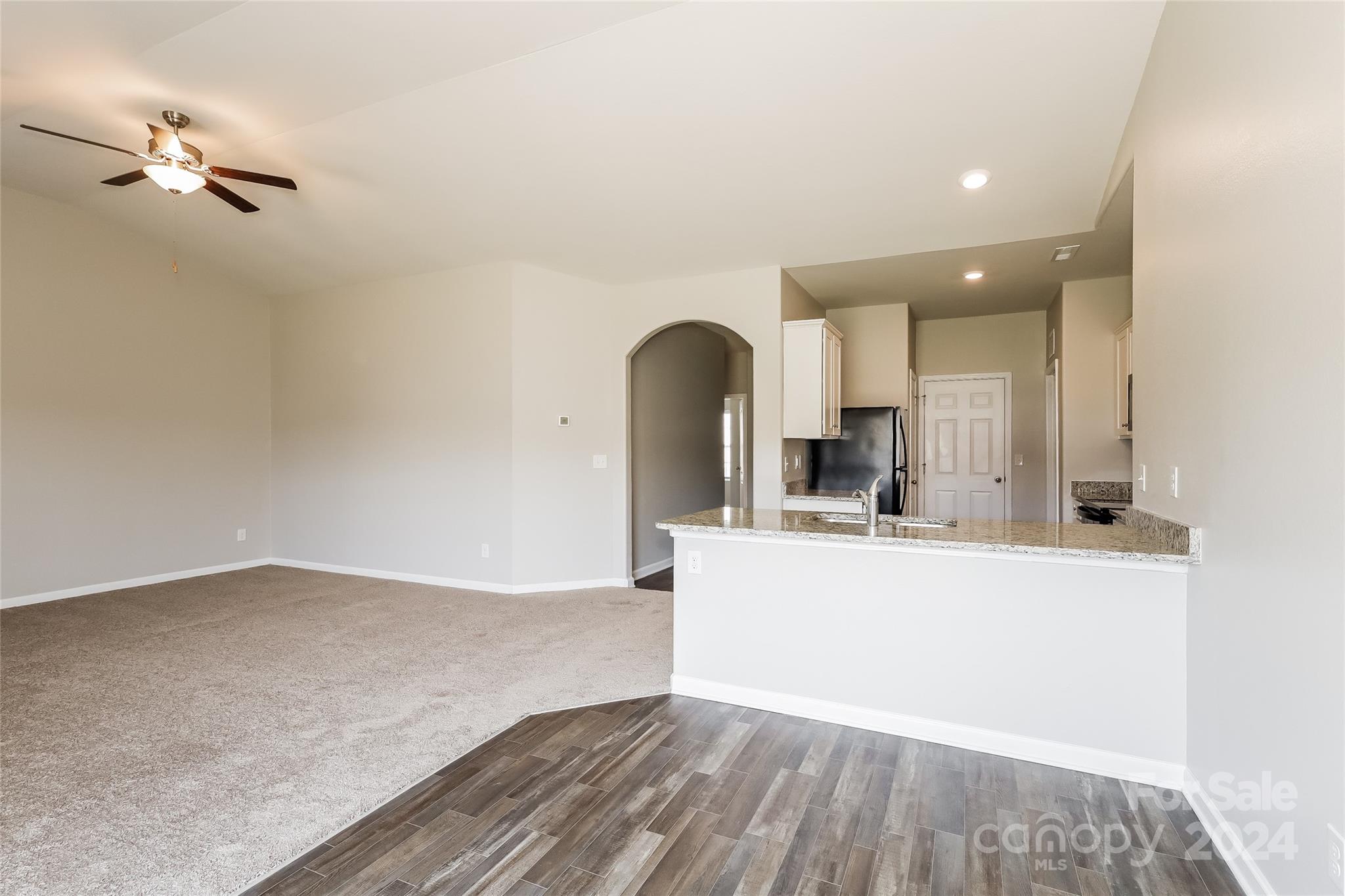 7323 Amberly Hills Road Charlotte, NC 28215 - Photo 6 of 14 a view of a kitchen with kitchen island a sink wooden floor and a large window