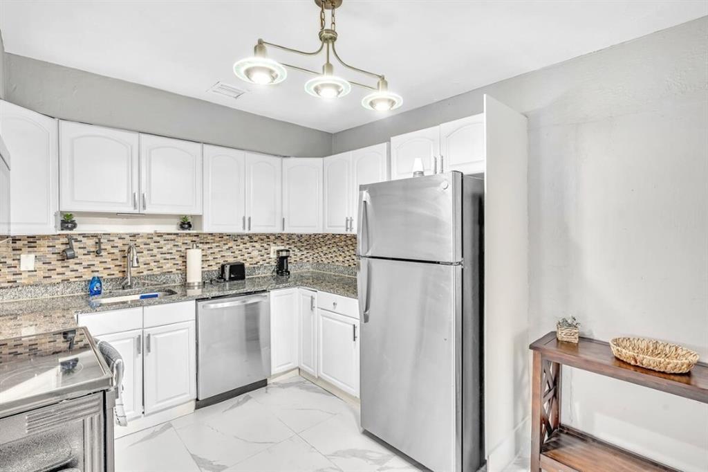 253 Southwest 7th Street, Unit A Dania Beach, FL 33004 - Photo 3 of 22 a kitchen with stainless steel appliances a refrigerator sink and cabinets