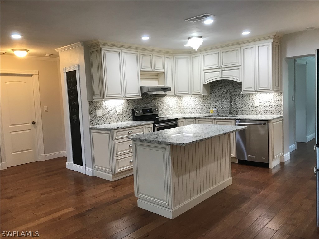 14660 Cemetery Road Fort Myers, FL 33905 - Photo 8 of 27 a kitchen with kitchen island granite countertop a sink cabinets and stainless steel appliances