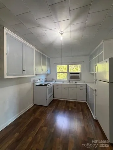 a kitchen with a wooden floors and white walls
