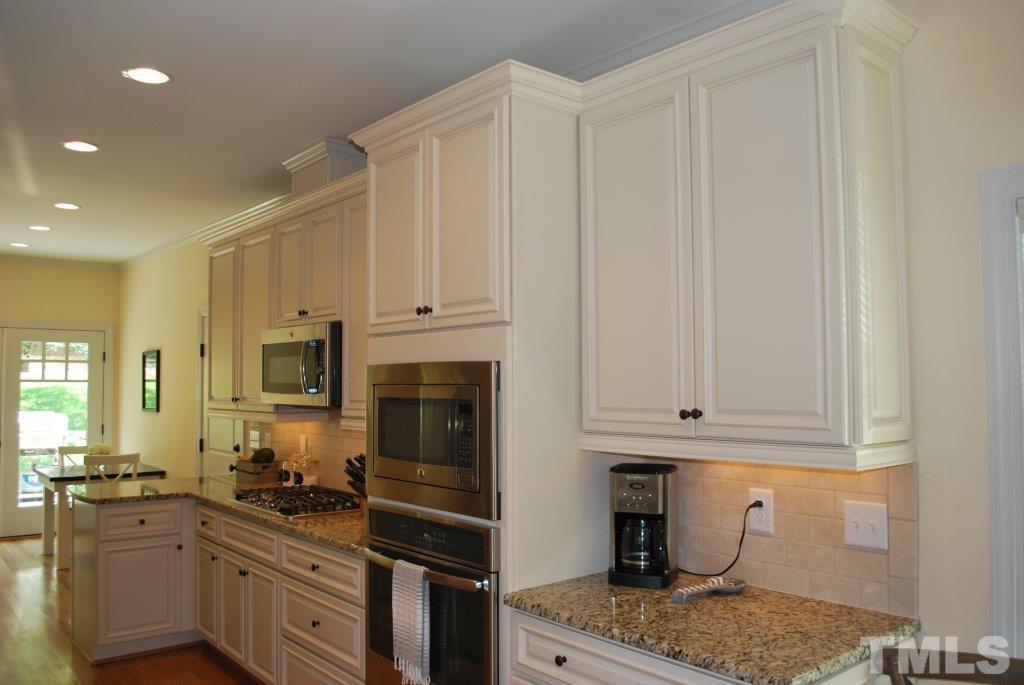 918 Dixie Trail Raleigh, NC 27607 - Photo 6 of 23 a kitchen with stainless steel appliances granite countertop a stove a sink and a refrigerator