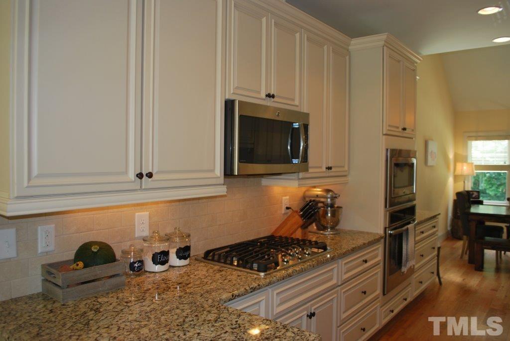 918 Dixie Trail Raleigh, NC 27607 - Photo 7 of 23 a kitchen with stainless steel appliances granite countertop a stove a sink and a microwave