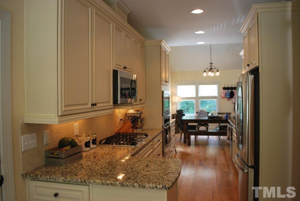 918 Dixie Trail Raleigh, NC 27607 - Photo 8 of 23 a kitchen with sink refrigerator and cabinets