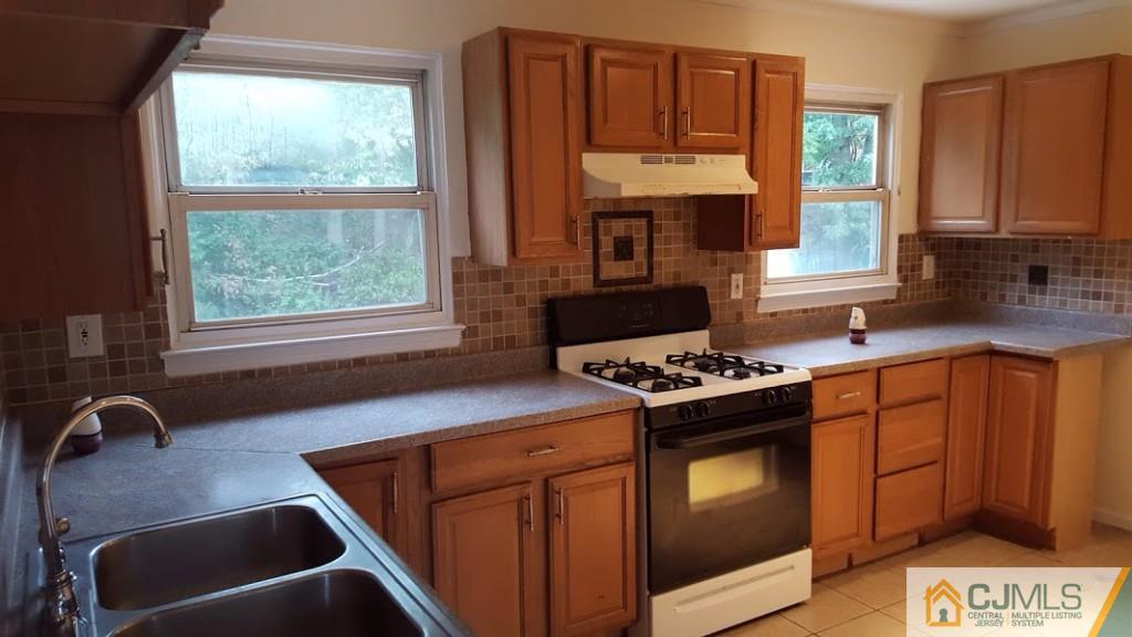 4 Wilcox Road New Brunswick, NJ 08901 - Photo 5 of 14 a kitchen with stainless steel appliances granite countertop a stove a sink dishwasher and a microwave oven with cabinets