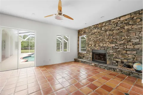 a view of an empty room with a fireplace and a window