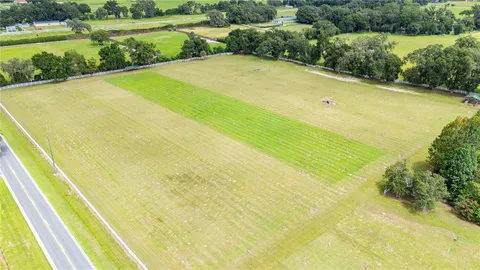 an aerial view of a house with a yard and lake view
