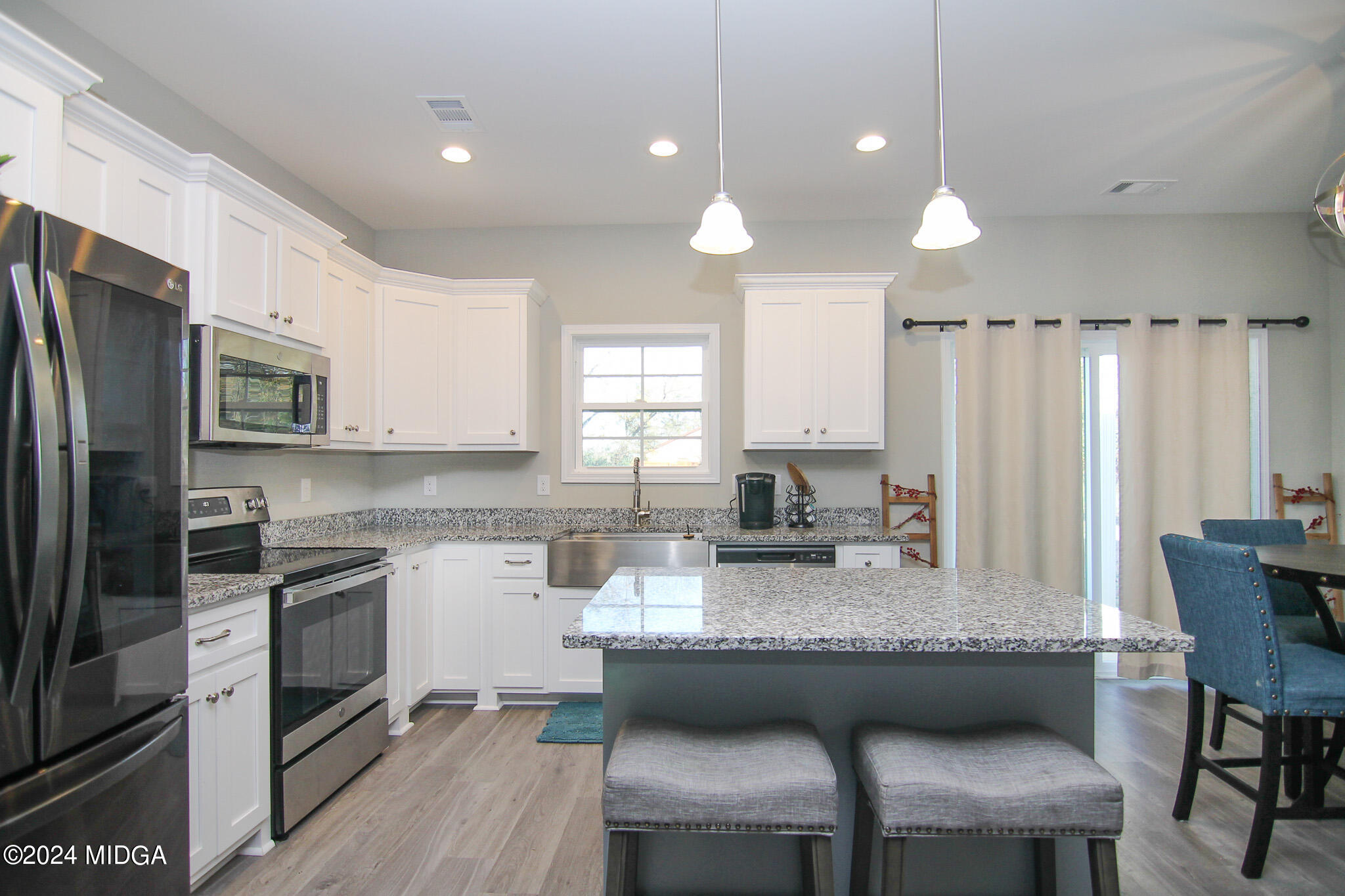 144 Summit Drive Byron, GA 31008 - Photo 11 of 27 a kitchen with kitchen island granite countertop a table chairs sink refrigerator and cabinets