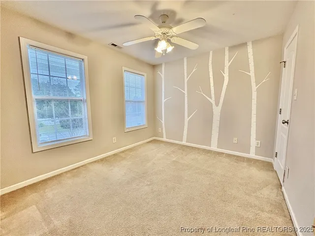 a view of large green field with house in the background