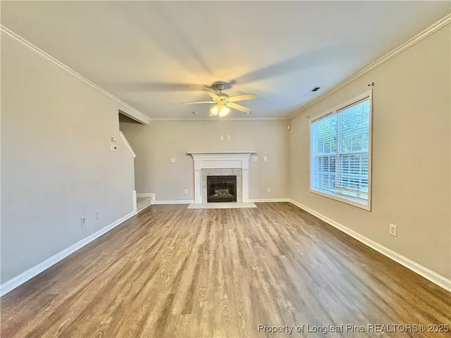 a view of an empty room with a fireplace and a window