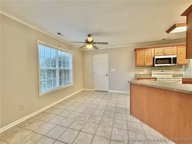 a view of kitchen with granite countertop cabinets and window