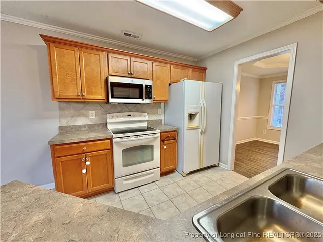a kitchen with stainless steel appliances granite countertop a refrigerator sink and stove