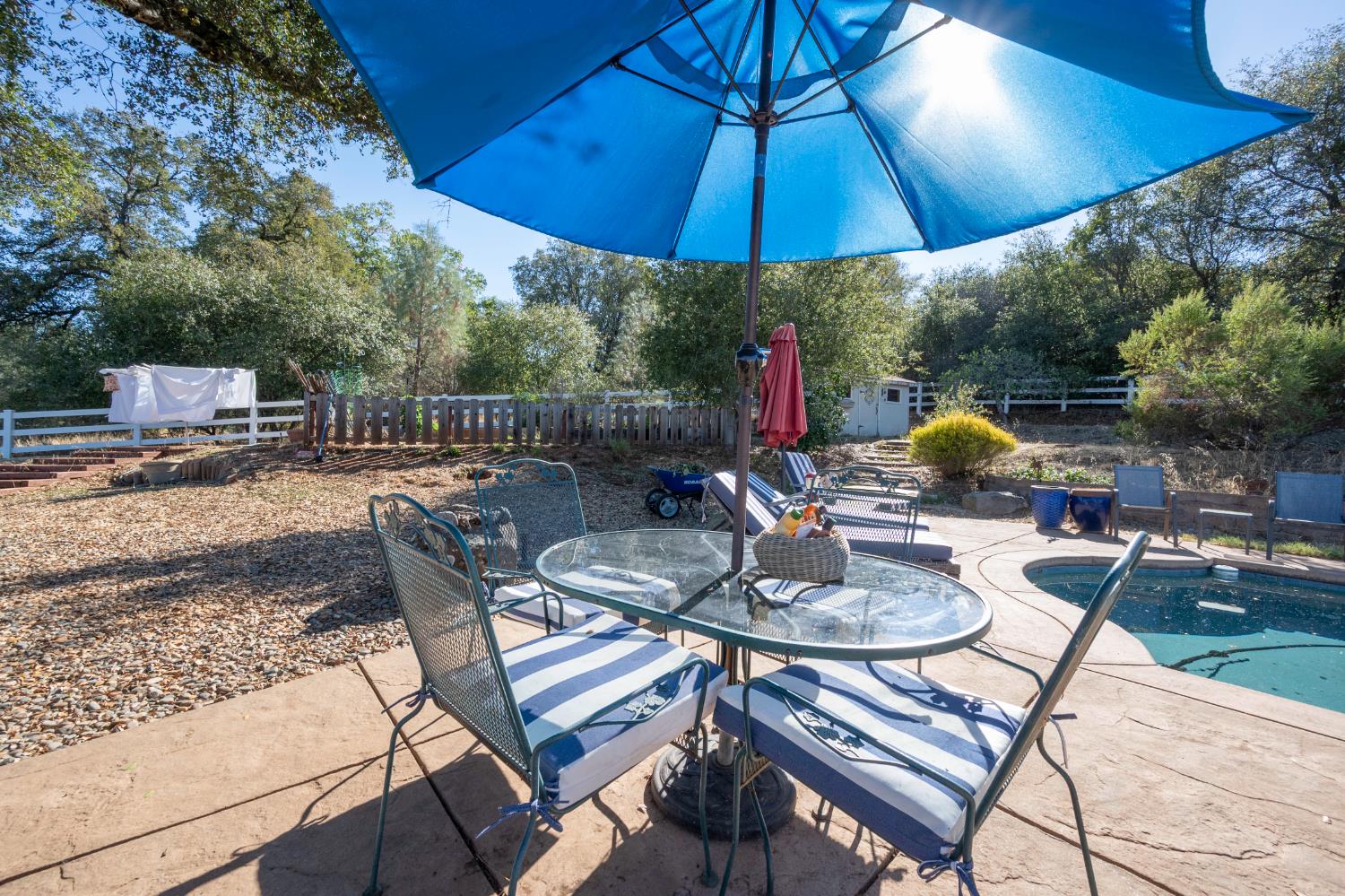 4770 Pedro Hill Road Pilot Hill, CA 95664 - Photo 55 of 87 a view of a patio with a table and chairs under an umbrella