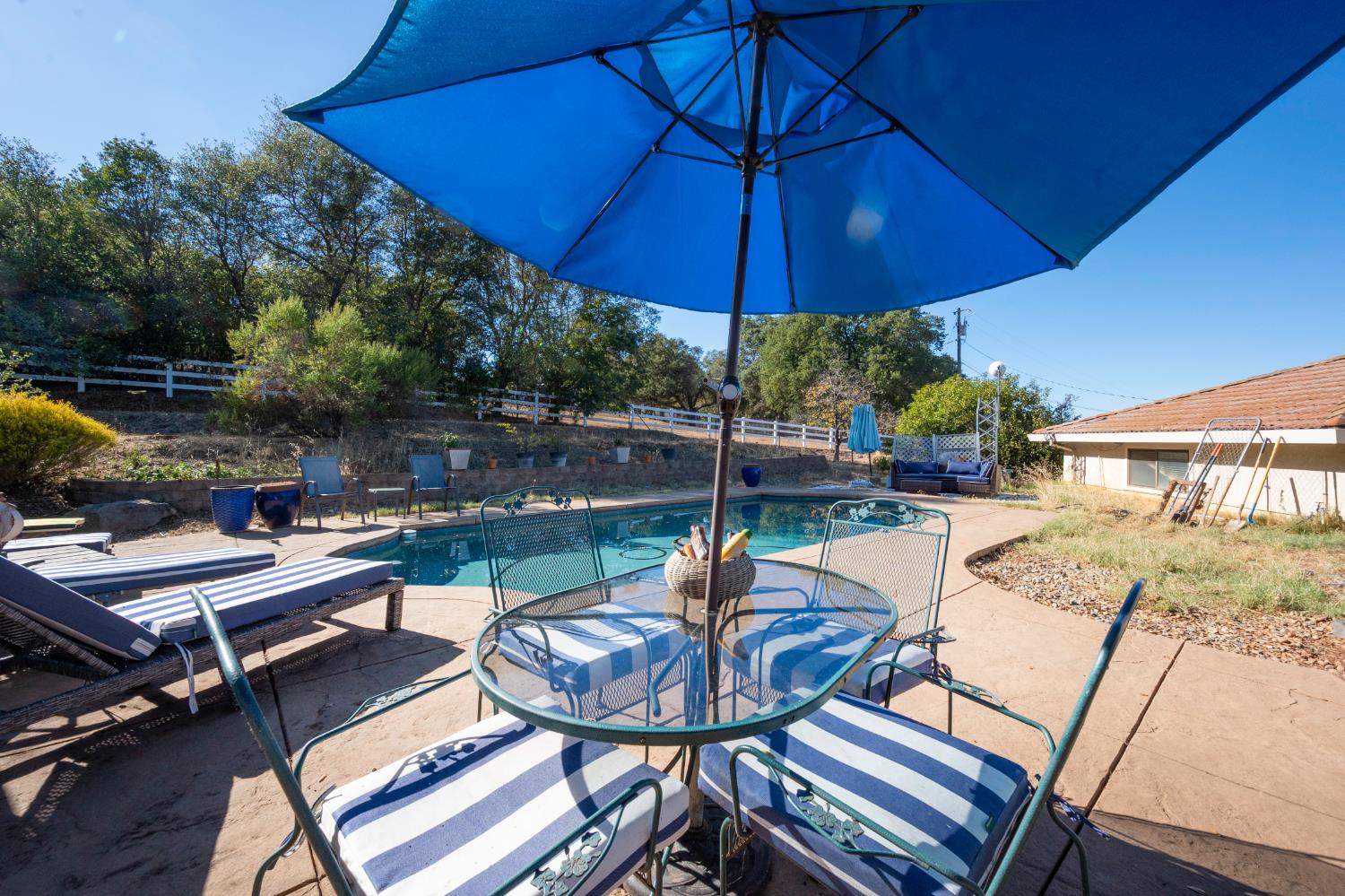4770 Pedro Hill Road Pilot Hill, CA 95664 - Photo 56 of 87 a view of a patio with table and chairs under an umbrella