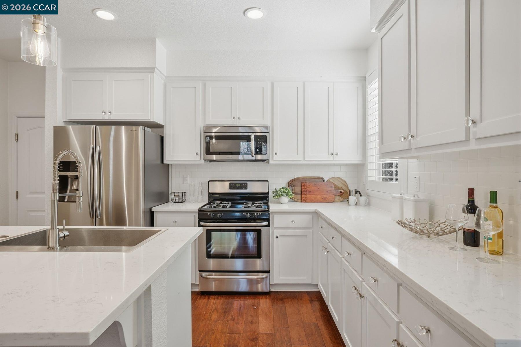 22640 Filbert Street Hayward, CA 94541 - Photo 18 of 60 a kitchen with kitchen island a sink white cabinets and stainless steel appliances