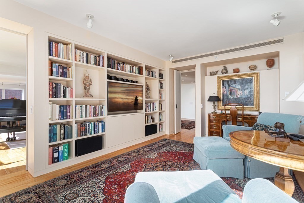 975 Memorial Drive, Unit 906 Cambridge, MA 02138 - Photo 12 of 37 a living room with furniture and a book shelf