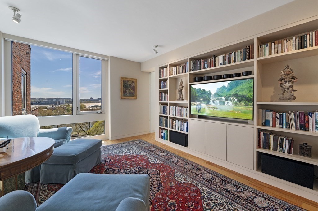 975 Memorial Drive, Unit 906 Cambridge, MA 02138 - Photo 13 of 37 a living room with furniture and a book shelf