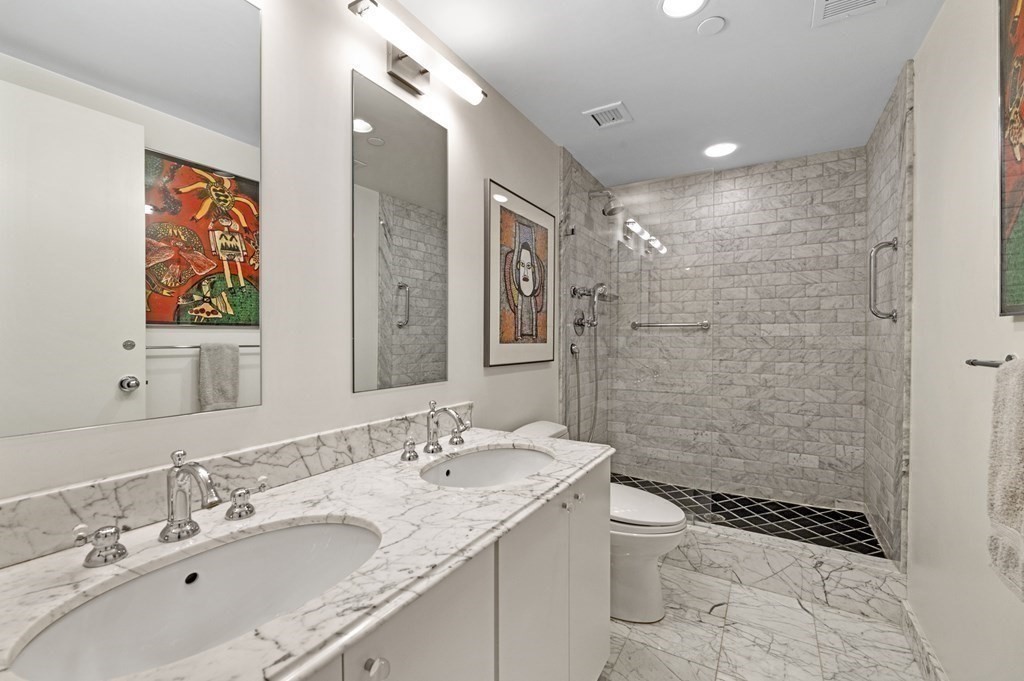 975 Memorial Drive, Unit 906 Cambridge, MA 02138 - Photo 22 of 37 a bathroom with a granite countertop sink a toilet a shower and a mirror