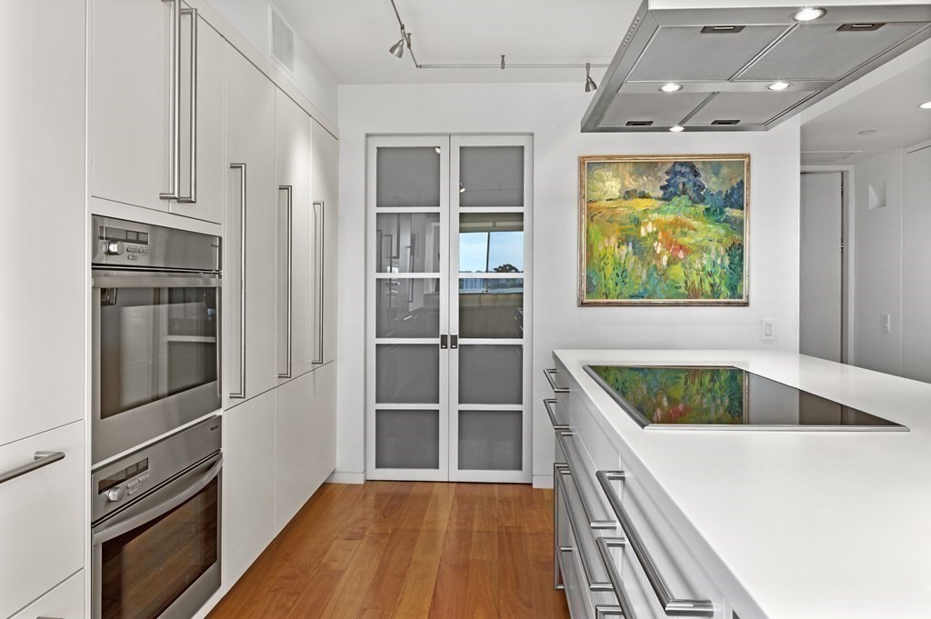 975 Memorial Drive, Unit 906 Cambridge, MA 02138 - Photo 10 of 37 a kitchen with stainless steel appliances granite countertop a refrigerator and a sink