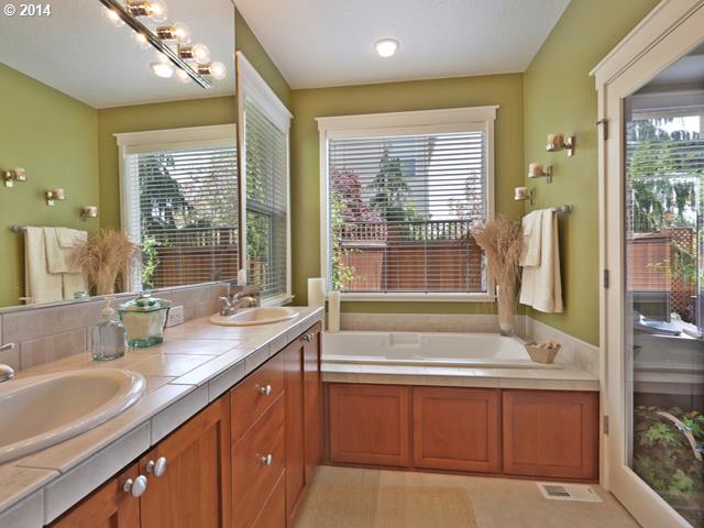 4920 Northwest 146th Place Portland, OR 97229 - Photo 10 of 16 a bathroom with a double vanity sink bathtub and next to a window